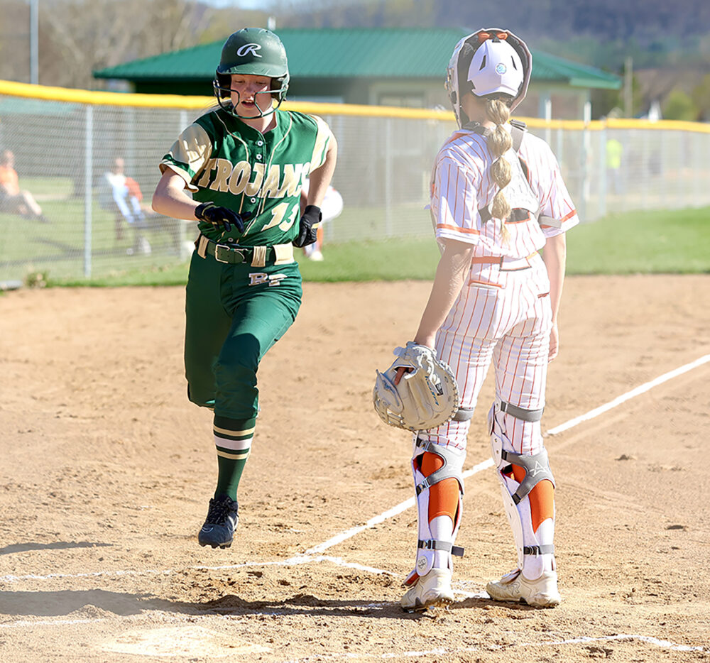Rushford-Peterson Alannah Skalet scores an early run in the Trojans game with TRC-West leading St. Charles, but the Saints prevailed 11-4. Photo by Craig Johnson