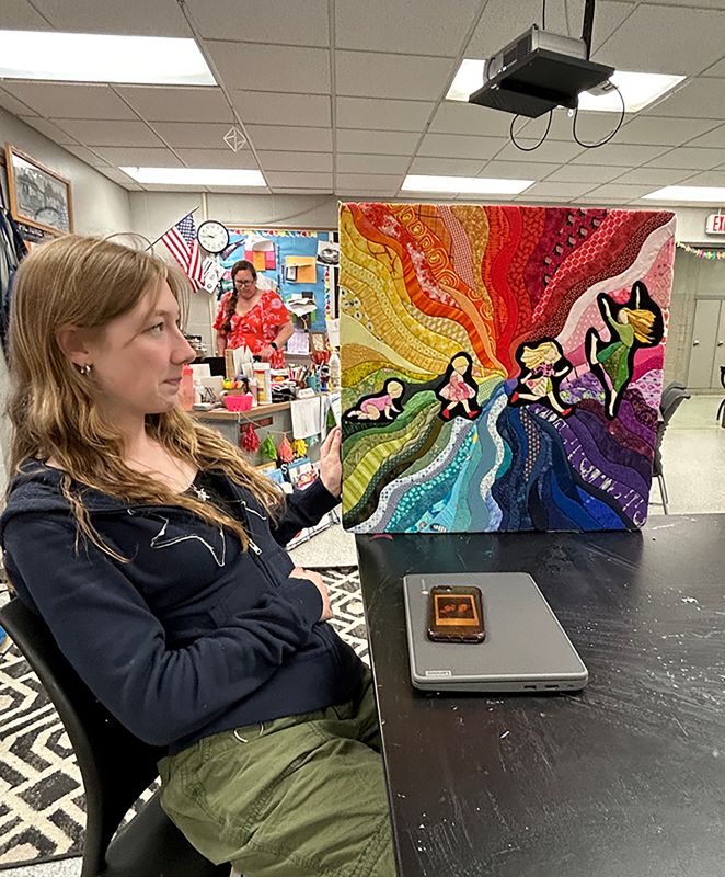 Ayla Madland with her quilt wall hanging.