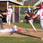 Houston’s Hector Steinfeldt will slide safely into home ahead of the tag by Chatfield’s Andrew Eickhoff in the teams’ non-conference game, a 15-5 Gopher win in six innings, Chatfield’s first victory. Hurricane Axel Vix is also shown (near). Photo by Leif Erickson
