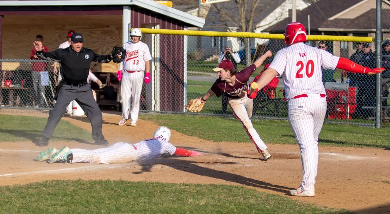 Houston’s Hector Steinfeldt will slide safely into home ahead of the tag by Chatfield’s Andrew Eickhoff in the teams’ non-conference game, a 15-5 Gopher win in six innings, Chatfield’s first victory. Hurricane Axel Vix is also shown (near). Photo by Leif Erickson