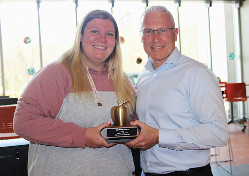 Teacher of the Year 2026 Courtney Graves received the Golden Apple Award from Jason Sethre.